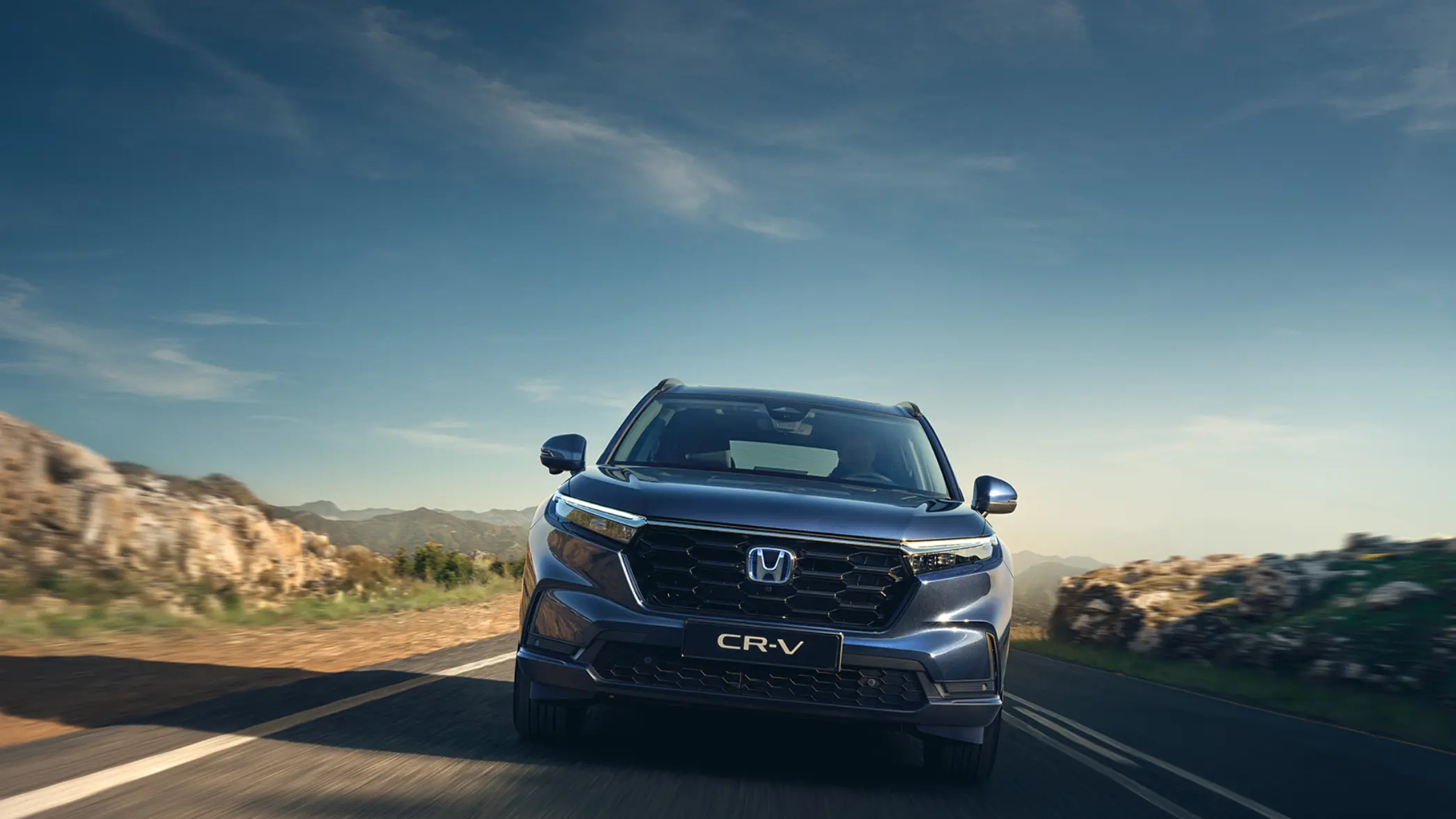 Detailný záber na koleso a bok zaparkovaného vozidla CR-V Hybrid SUV, s figurantom.